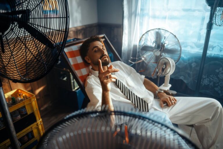Uomo che si rinfresca davanti ai ventilatori in una stanza