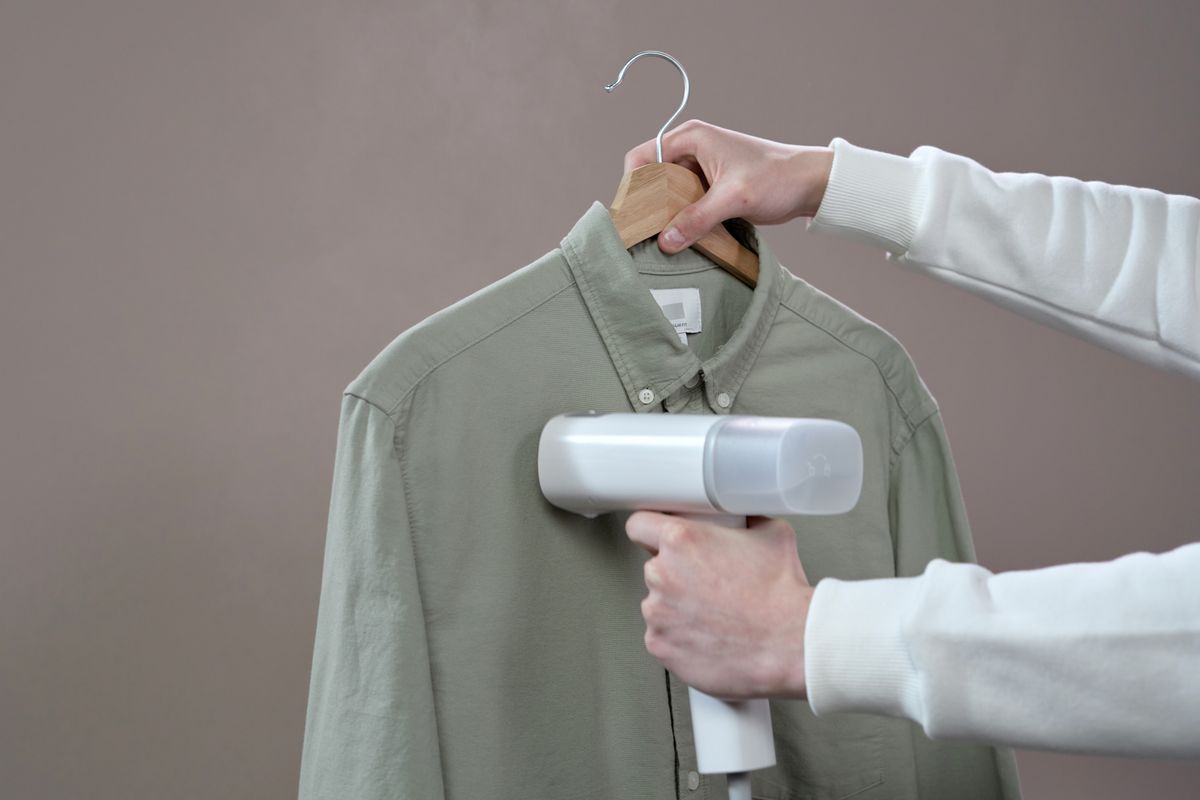 Stiratrice verticale portatile a vapore su una camicia appesa