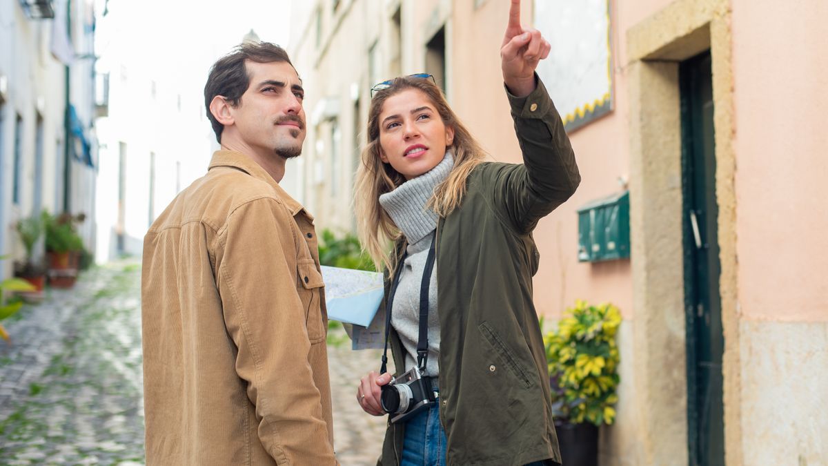 Due persone si parlano per strada durante un viaggio chiedendo indicazioni