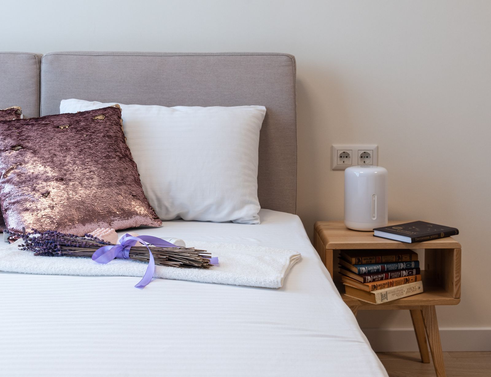 Umidificatore bianco appoggiato sul comodino accanto al letto