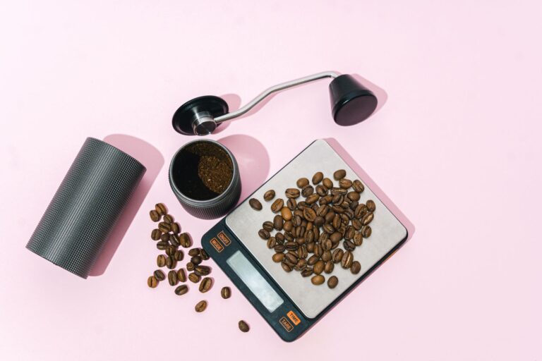 Bilancia digitale con chicchi di caffè, portafiltro e macinino visti dall alto